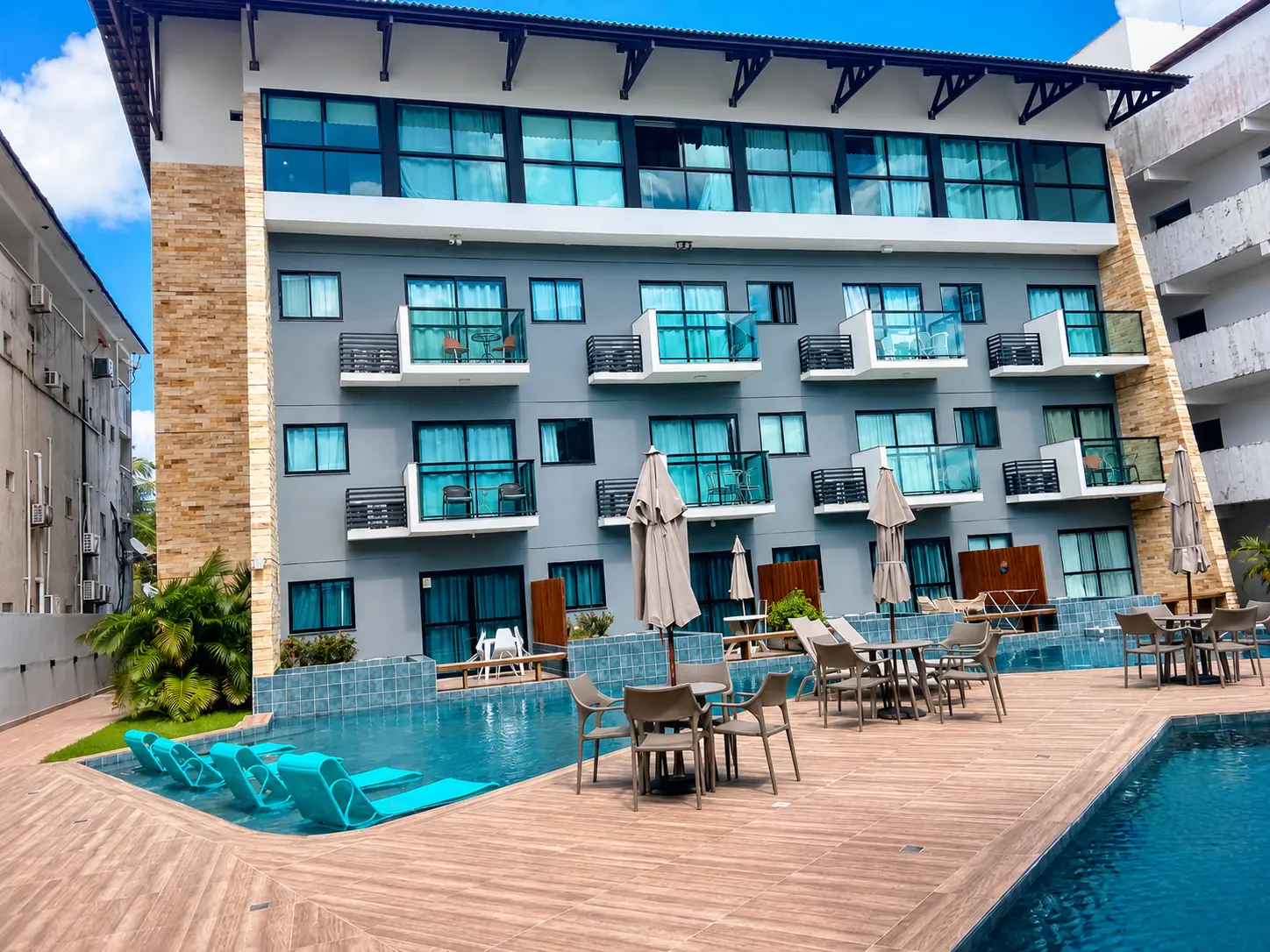Fachada da pousada com piscina e espreguiçadeiras